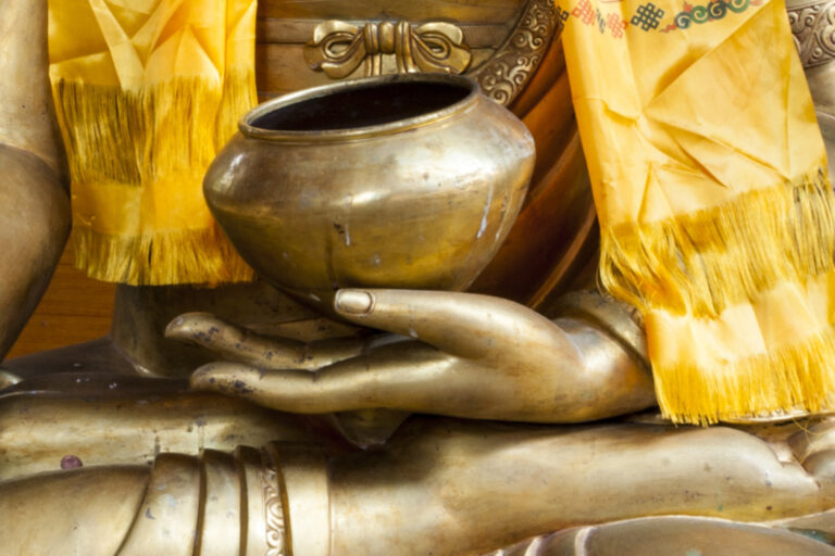 Nepal Himalaya Park, bestehend aus buddhistischer Stupa und hinduistischem Pavillon. Nahaufnahme sitzender Buddha aus Bronze oder Gold mit gelben, nepalesischen Gebetsschal.