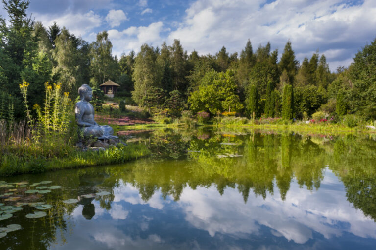 Nepal Himalaya Park, bestehend aus buddhistischer Stupa und hinduistischem Pavillon. Großer See mit Buddha-Figur um Grünen.